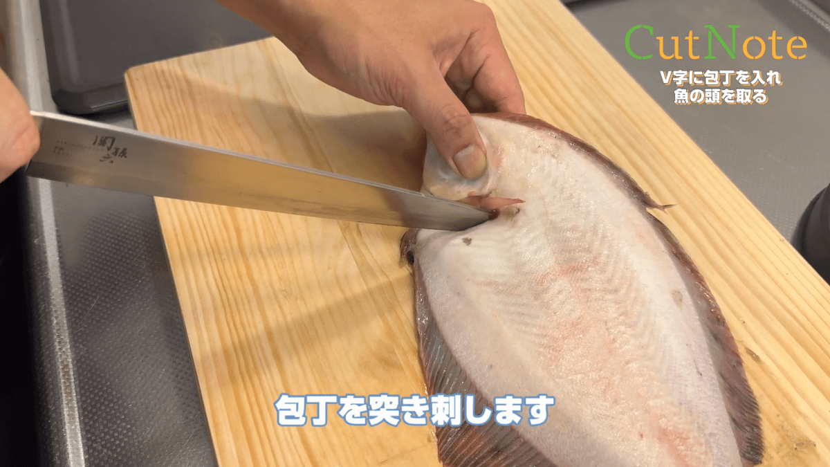 V字に包丁を入れ魚の頭を取る